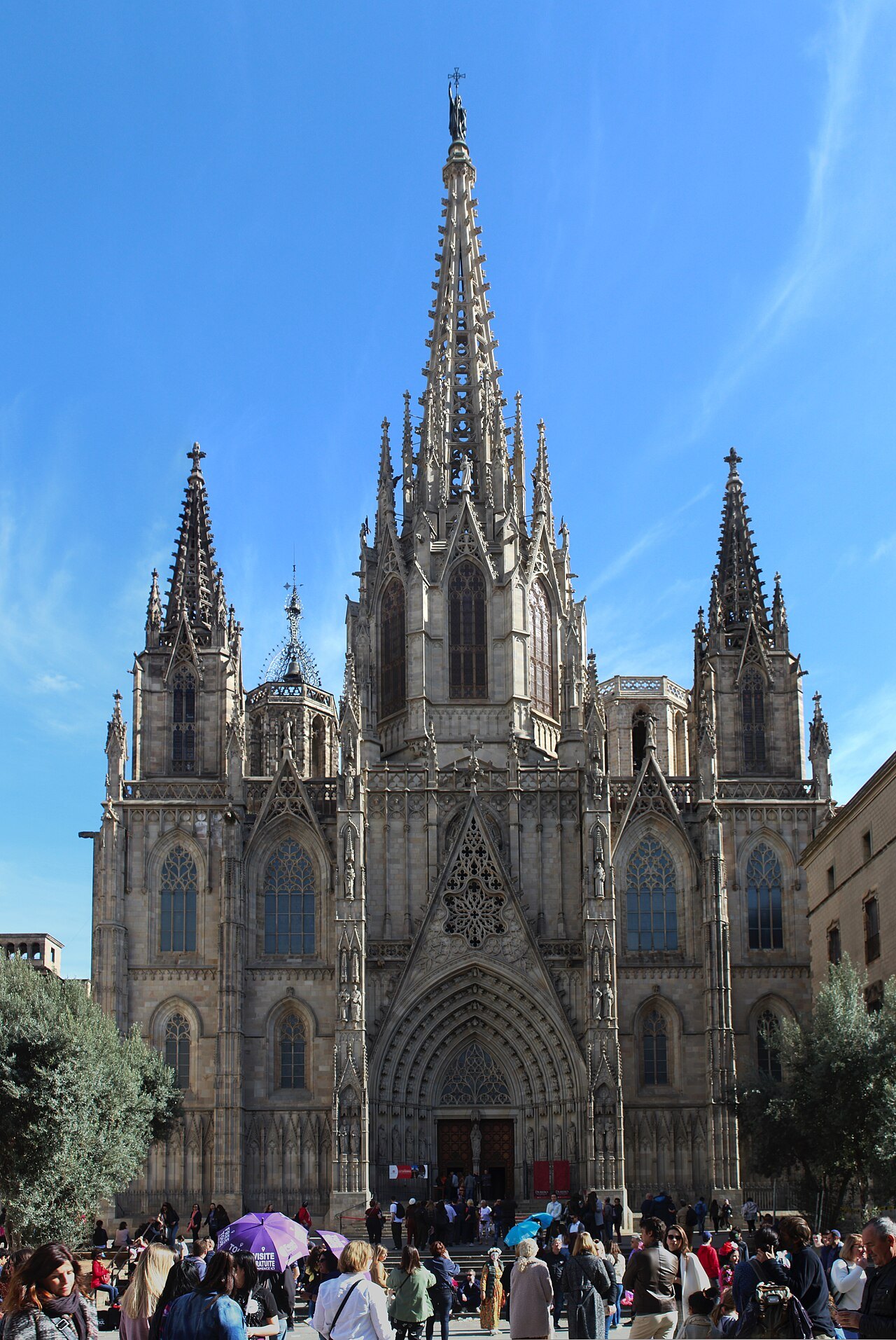 The cathedral's neo-Gothic façade and spire, with a crowd in the square below.