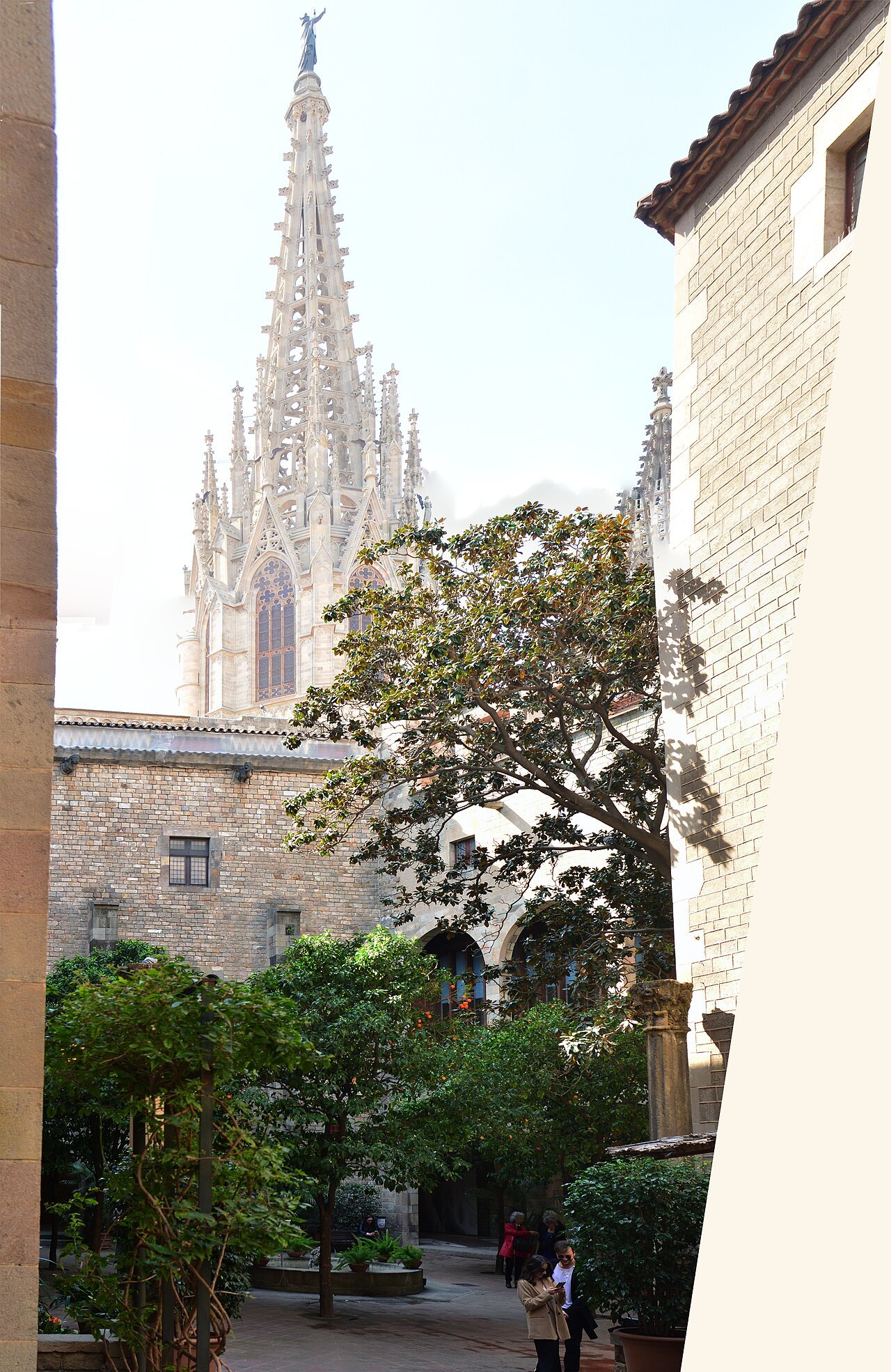The spire from the courtyard in brighter light, with the tree in the foreground.
