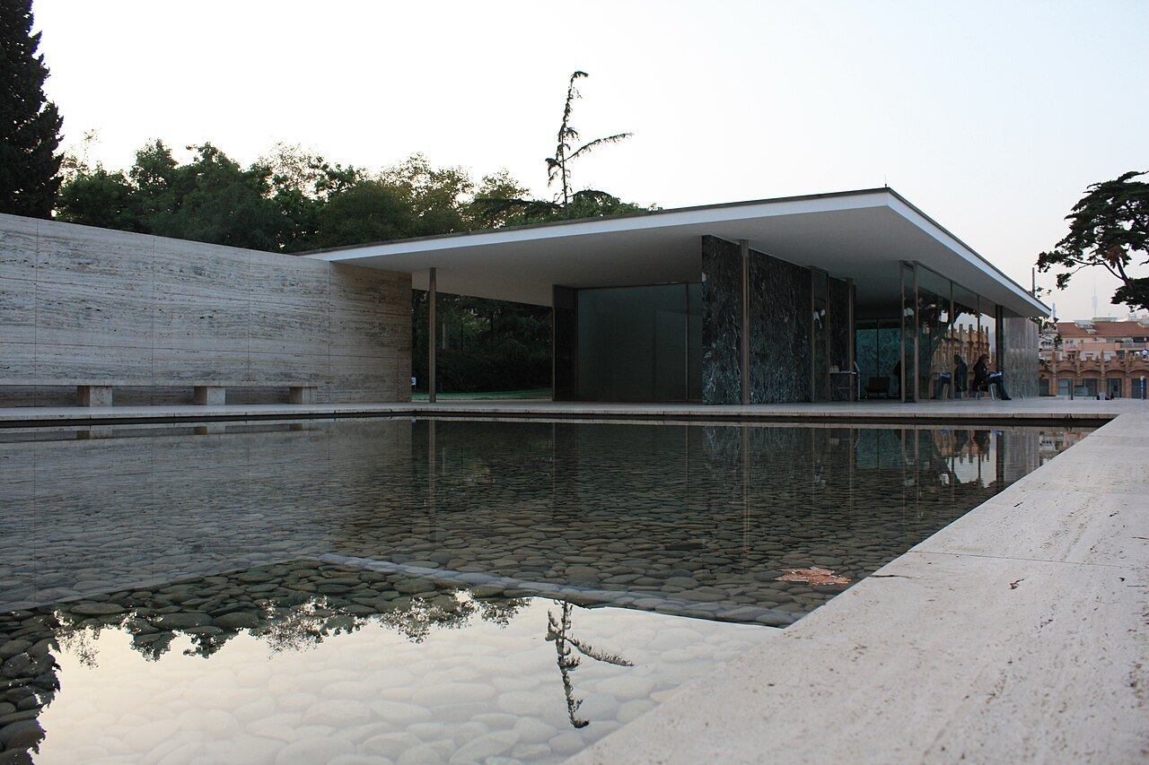 The long pool reflecting the pavilion's roof slab.