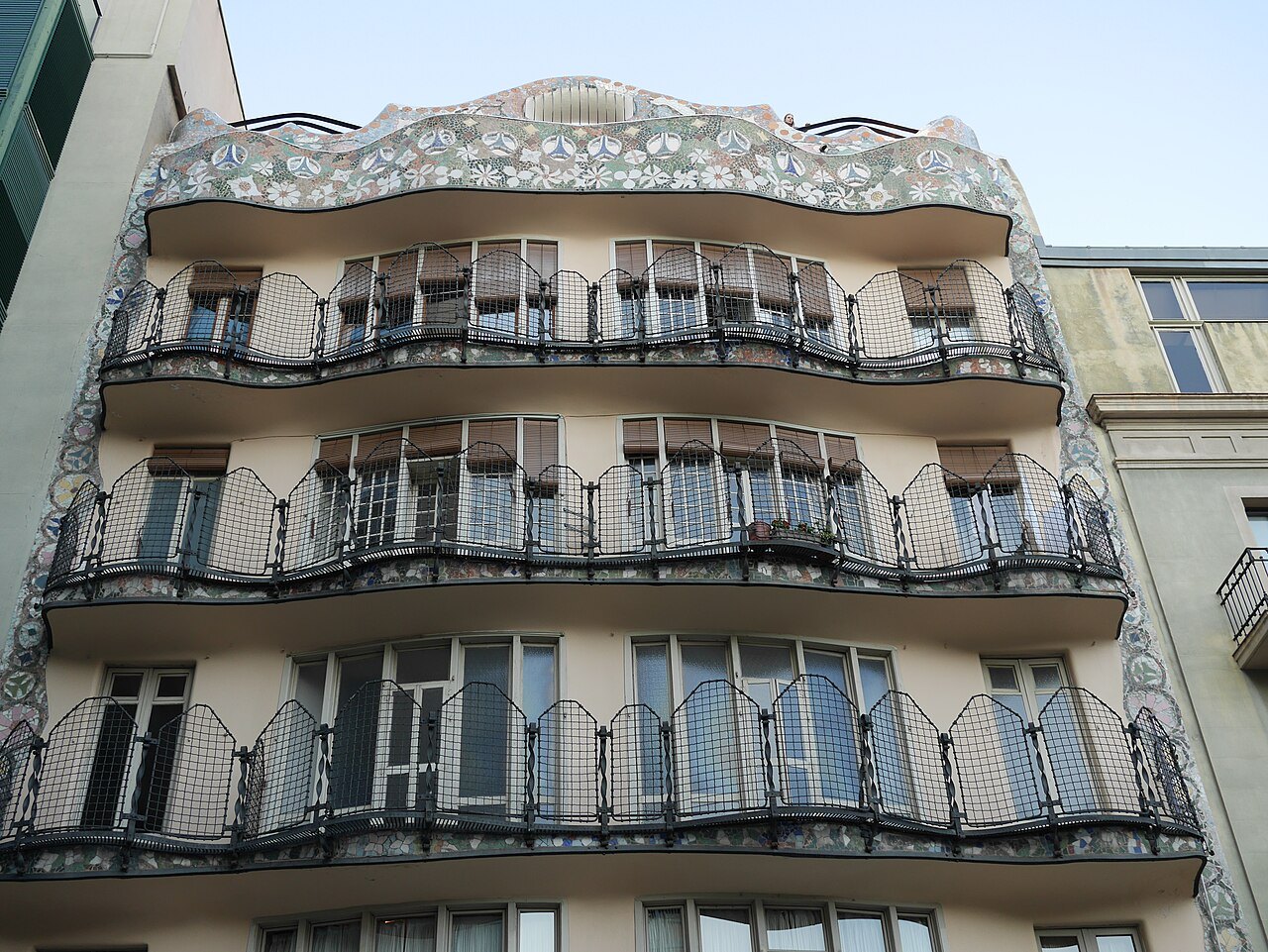 The back façade of Casa Batlló, tiers of curving iron balconies under a rippling cornice.