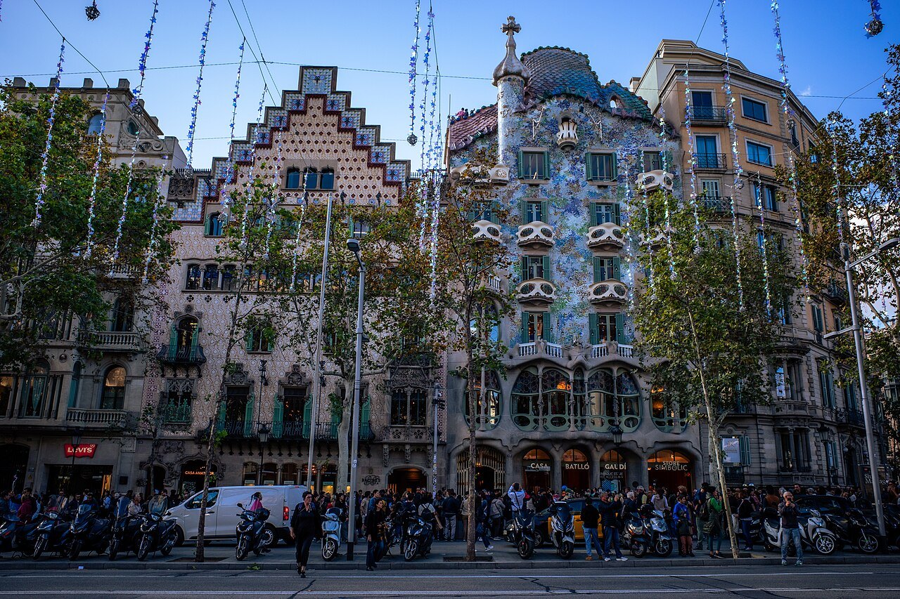 The Block of Discord from across the Passeig de Gràcia: the stepped gable of Casa Amatller beside Casa Batlló, with a crowd on the sidewalk.