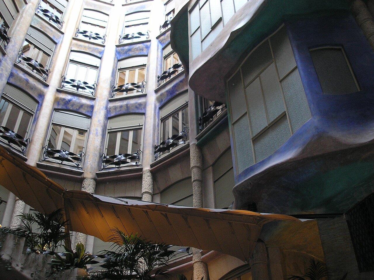 Looking up the inner courtyard of Casa Milà, windows and balconies curving around the light well.