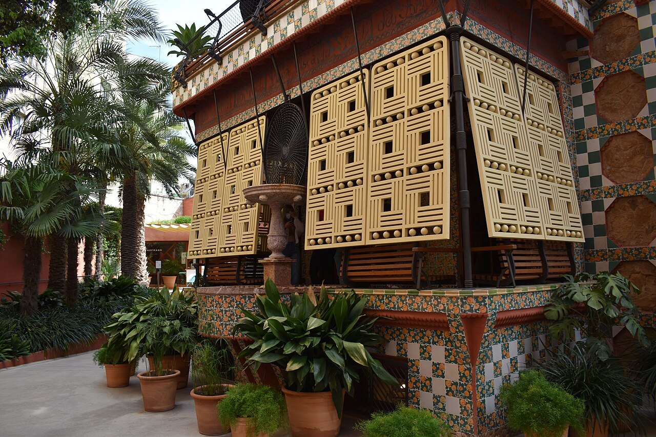 A wooden lattice screen and potted plants on the porch of Casa Vicens.