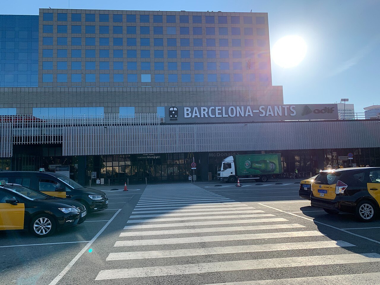 The entrance of Barcelona Sants, with taxis and a crossing in front.