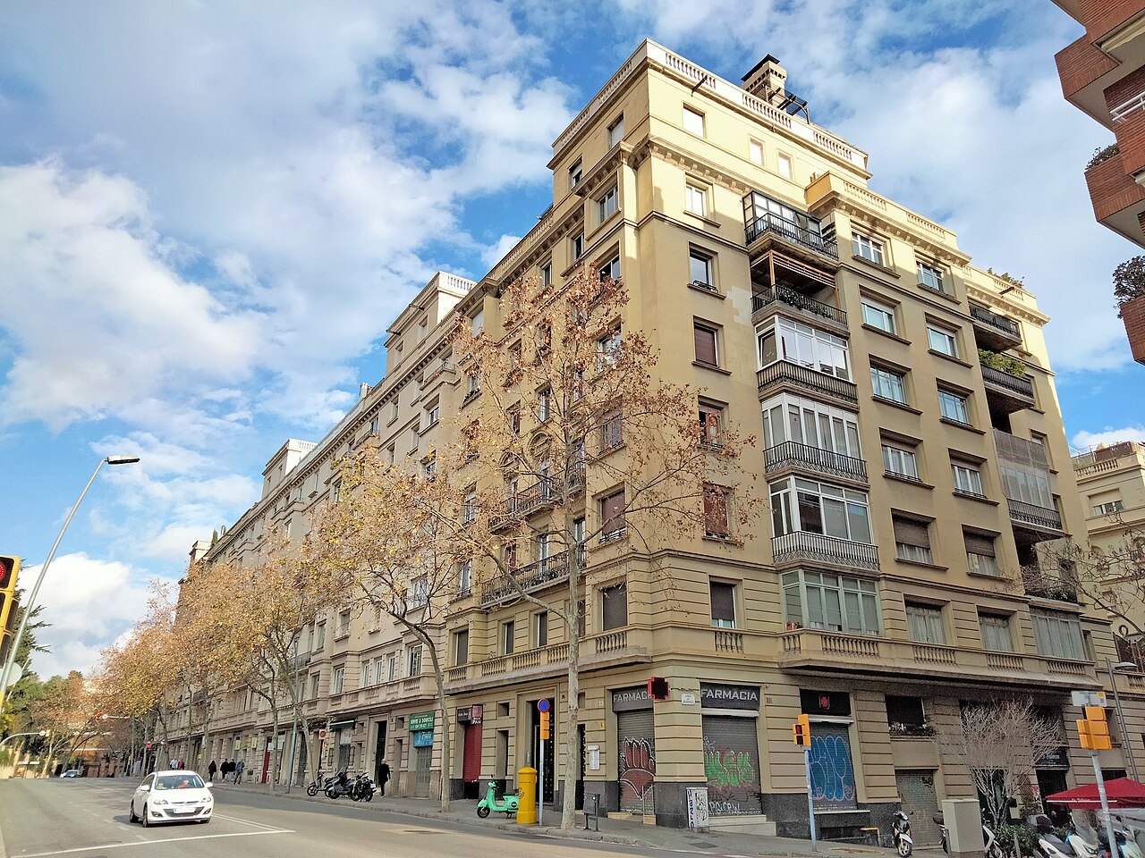A long apartment block on a wide avenue lined with bare trees.