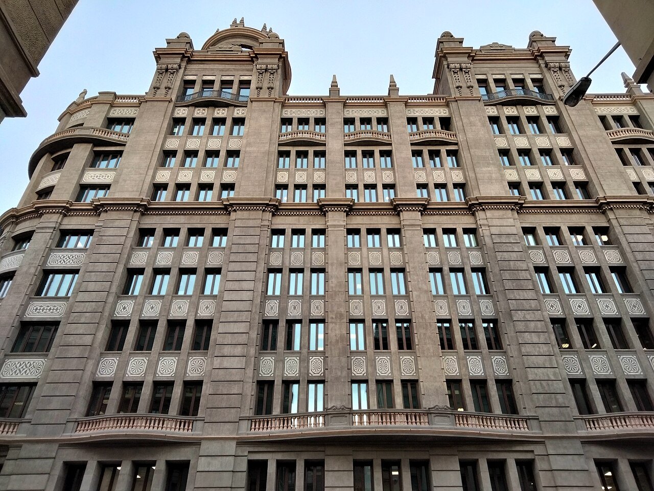 A tall stone office building on Via Laietana, its façade in regular bays.
