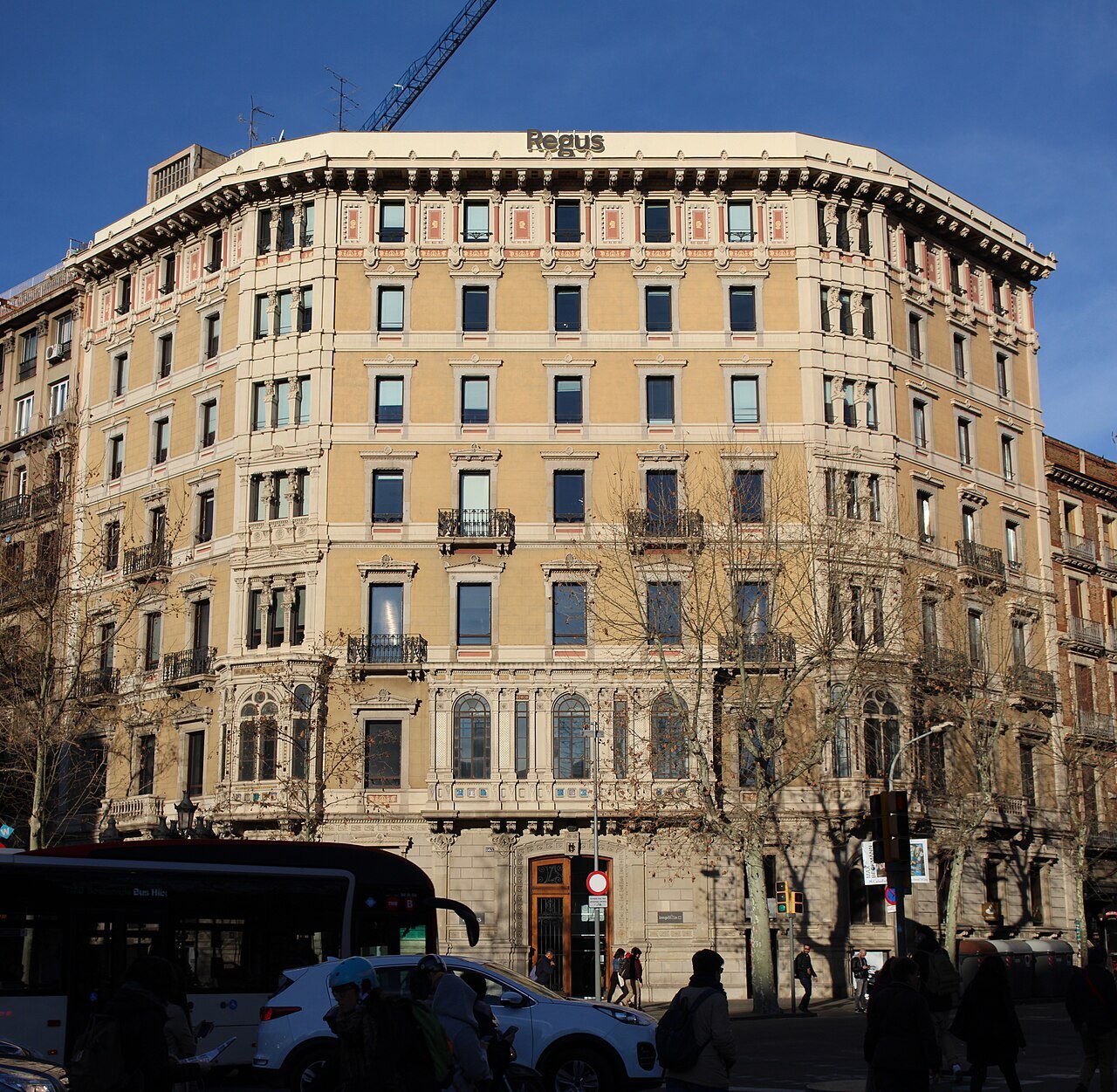A corner apartment building on the Gran Via, with a stone façade and rows of balconies.