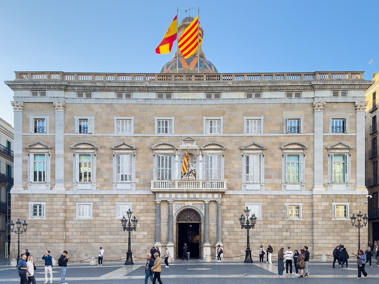 The main façade of the Palau de la Generalitat on Plaça Sant Jaume, with flags on the roof.