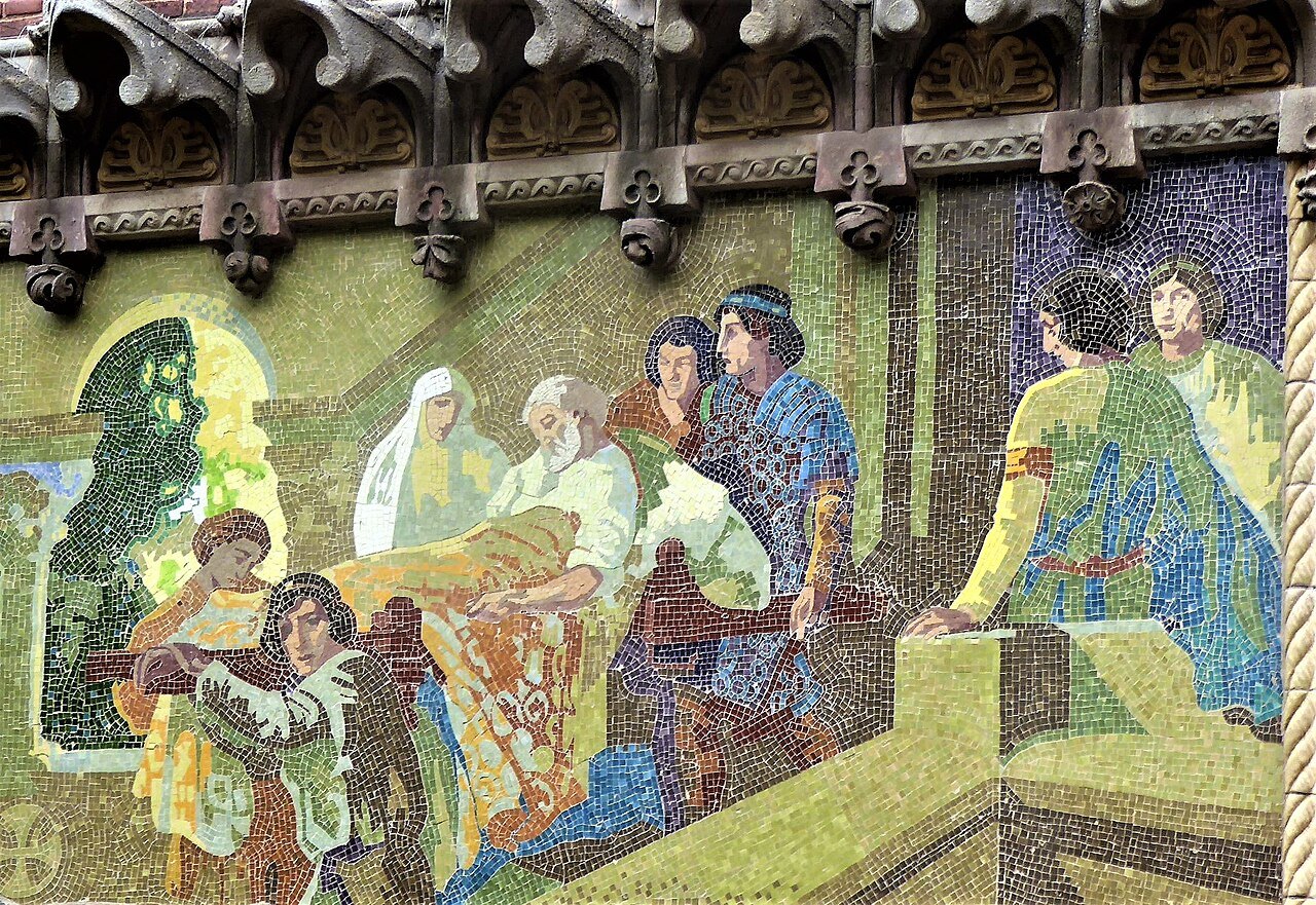 A tile mosaic of figures gathered around a bed, on a wall at Sant Pau.