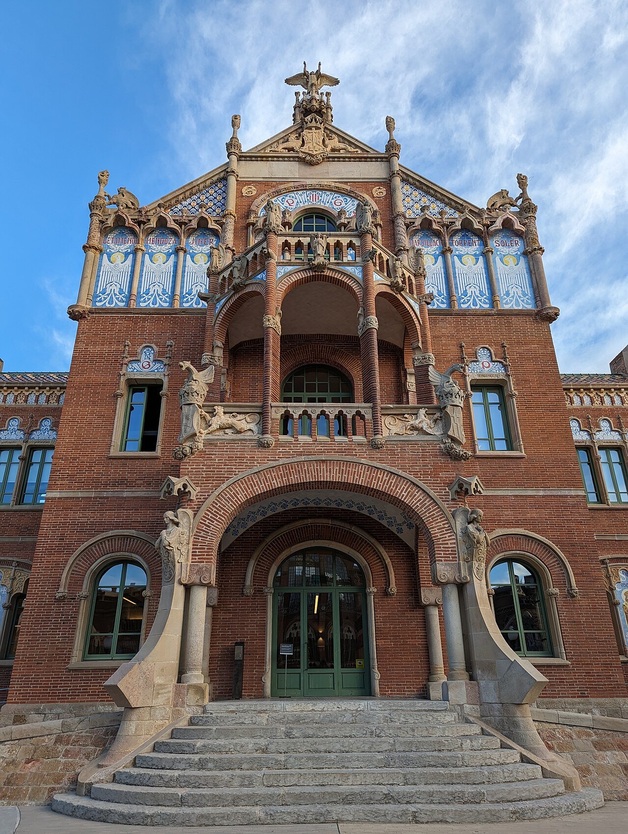 The arched entrance and steps of a brick pavilion at Sant Pau.