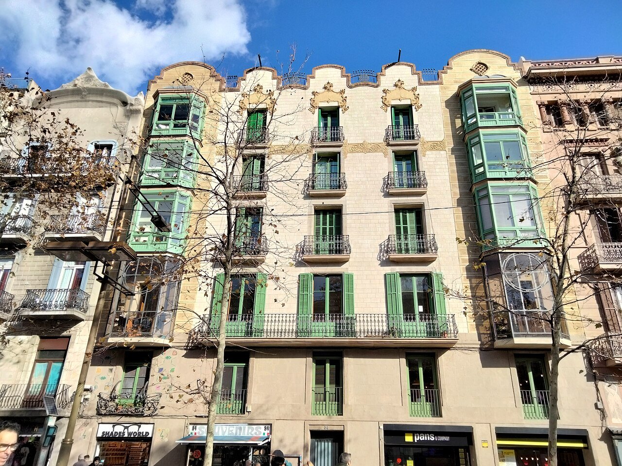A building with green-framed bay windows and balconies on the Rambla.
