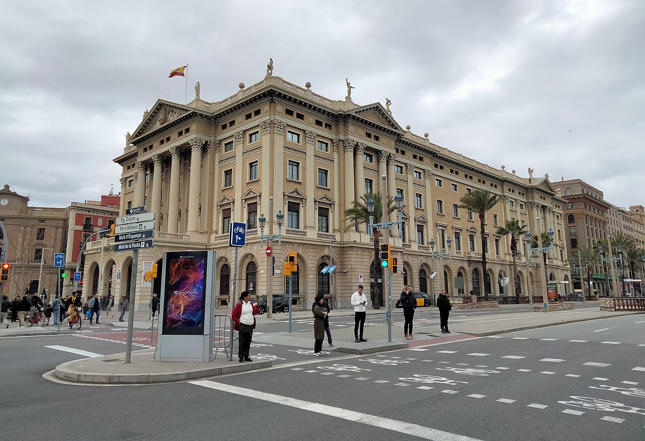 The Govern Militar, a stone building near the harbor, across a busy street.