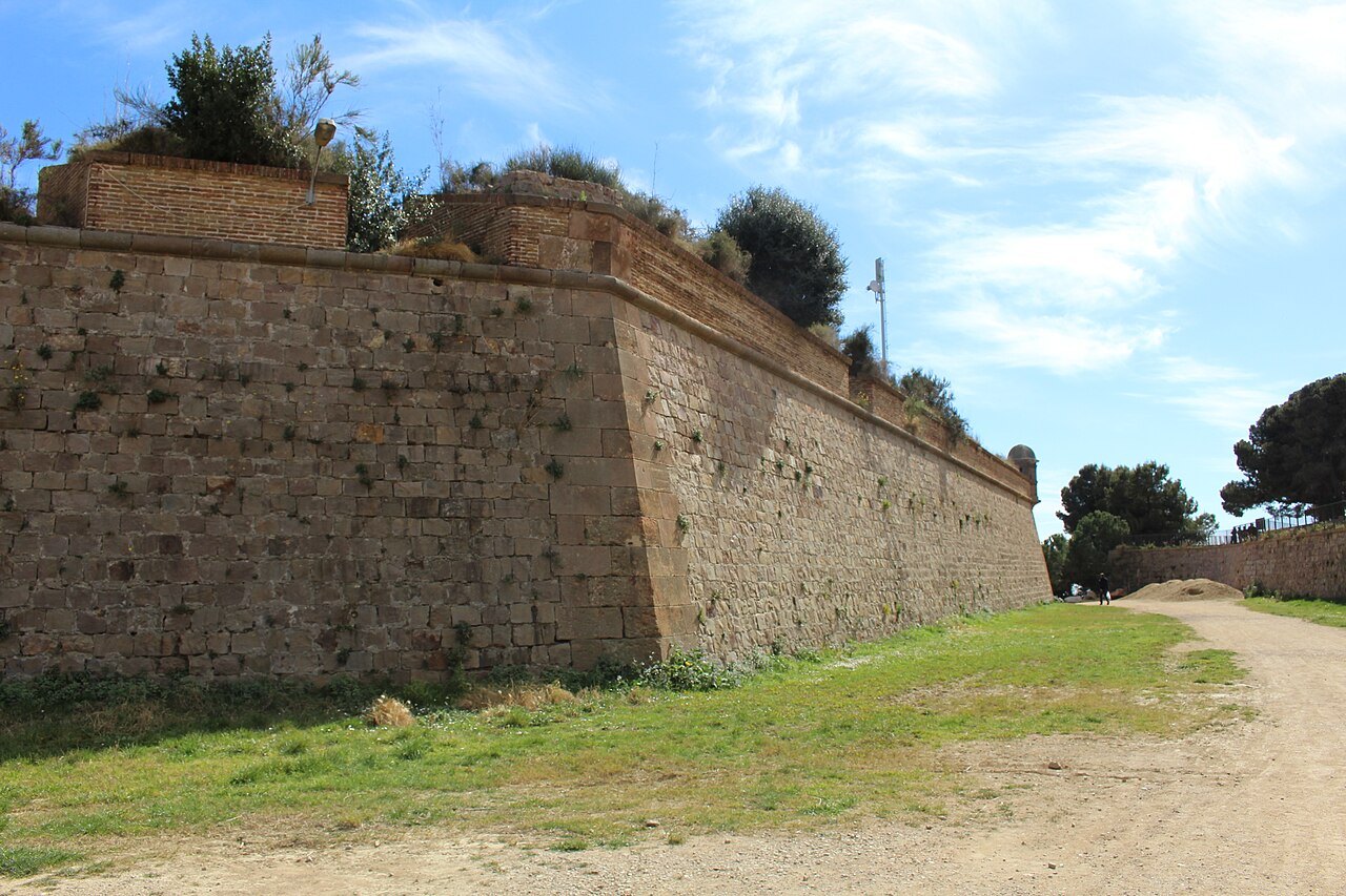 The long wall of Montjuïc castle, with plants growing along the top.