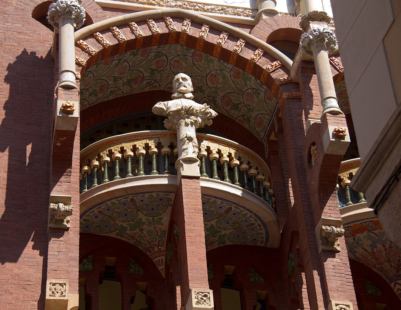 A balcony with a sculpted bust and slender columns on the Palau de la Música.