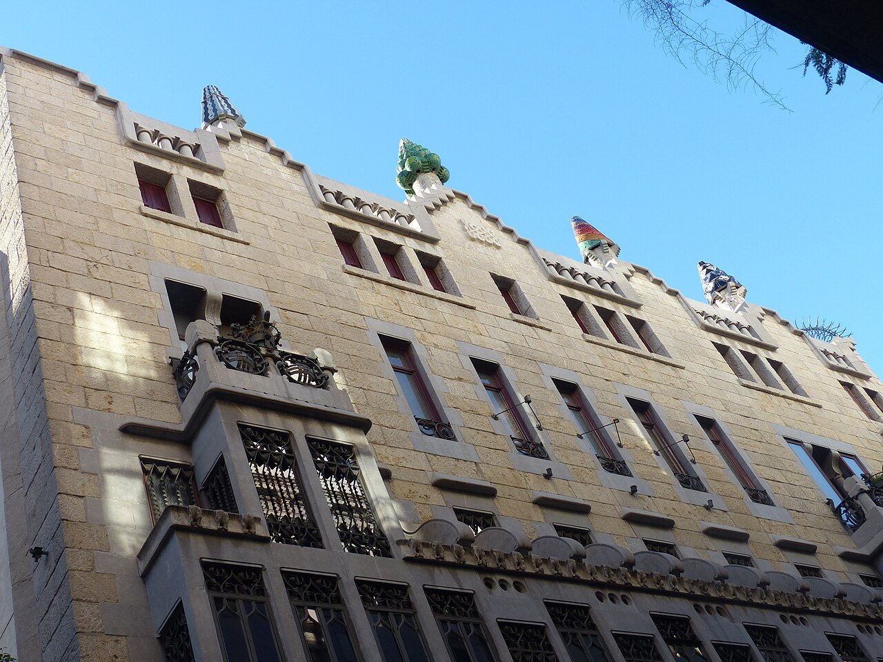 The Palau Güell's stone façade seen from the street, windows in regular rows.
