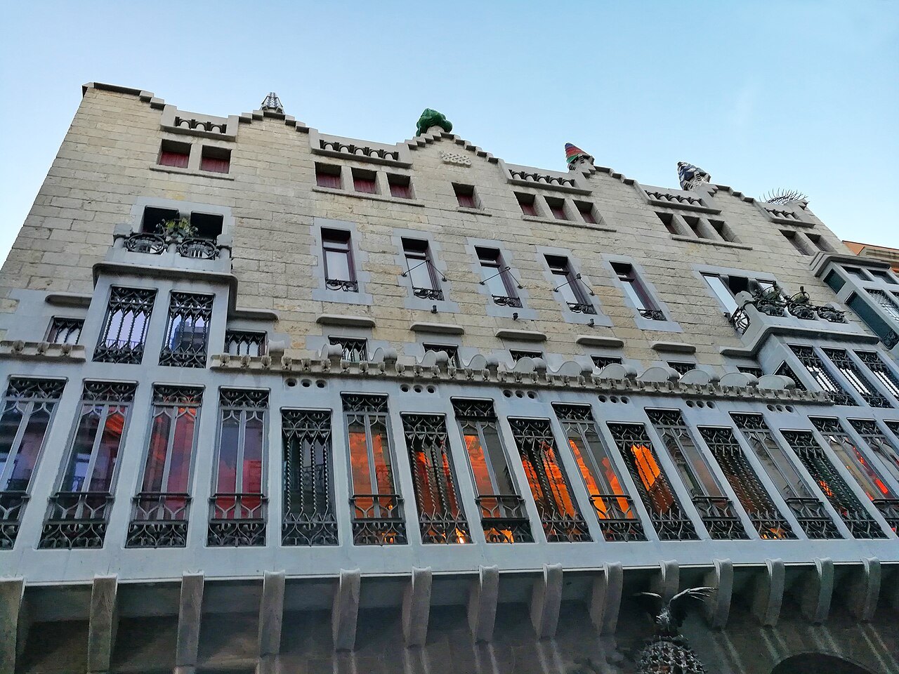 The façade of the Palau Güell seen from below, its tall gallery windows in rows.