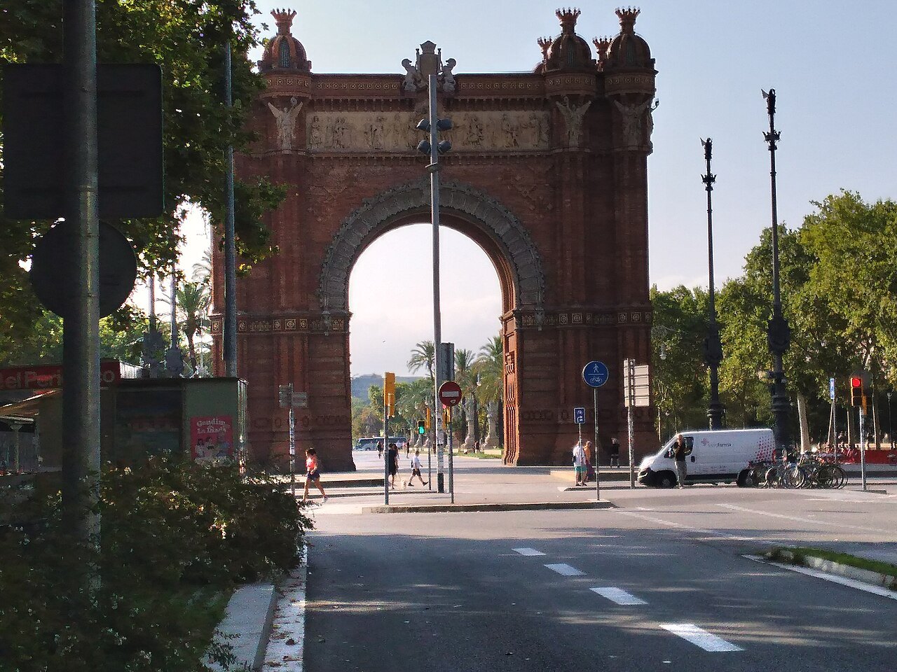 The Arc de Triomf seen across a street, with a van passing.