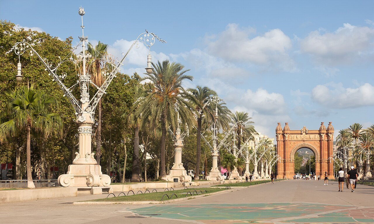 The Arc de Triomf at the end of a promenade lined with palms and tall lamp-posts.