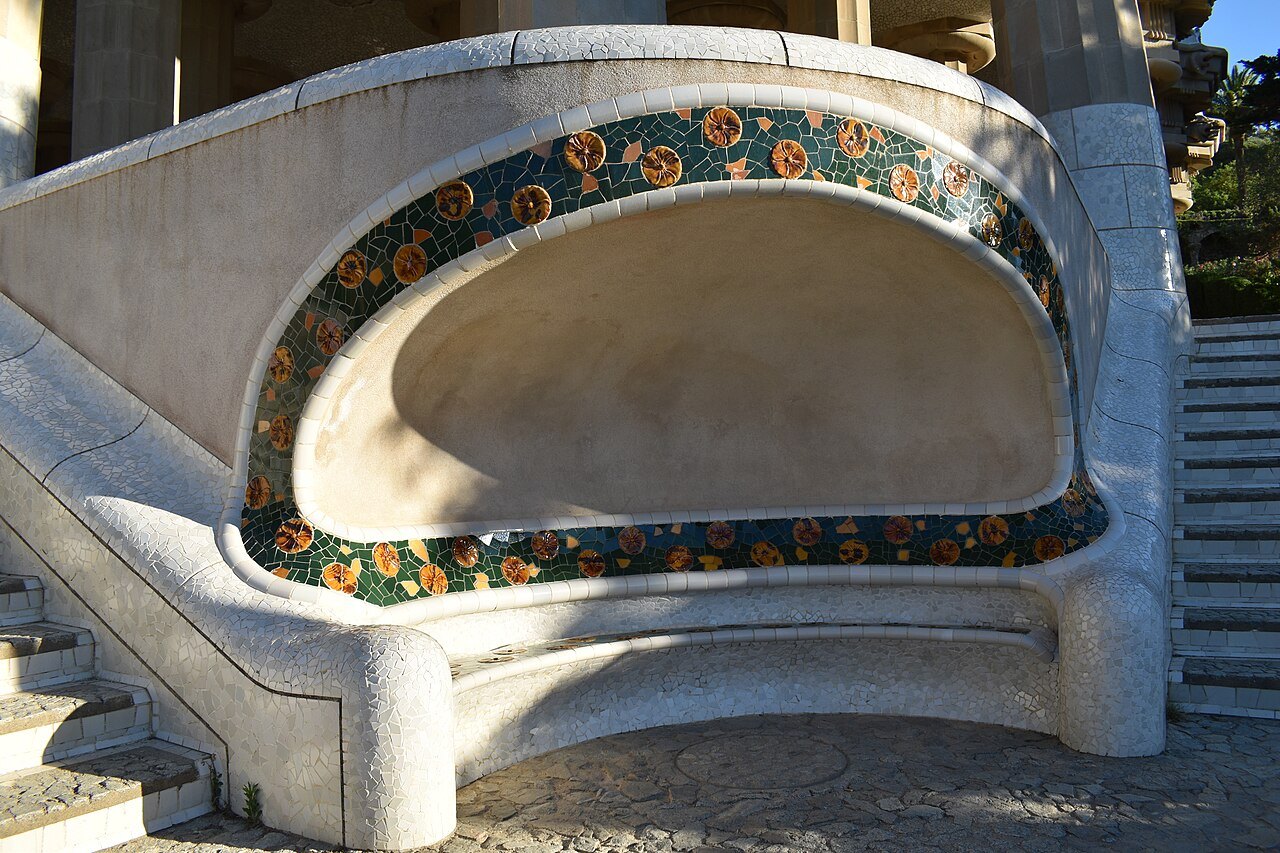 A curved stone seat edged with a band of colored mosaic in Park Güell.
