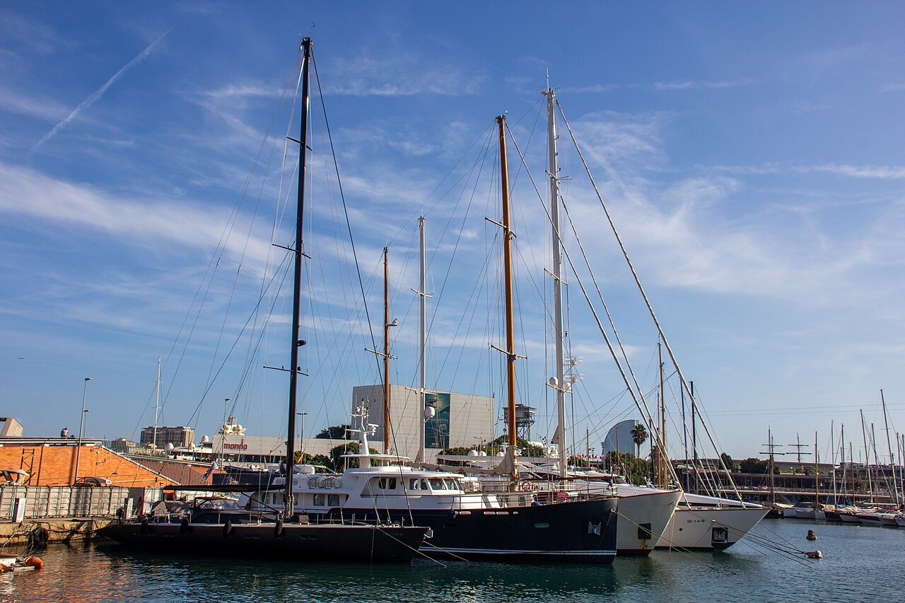 Tall-masted yachts moored in the harbor.