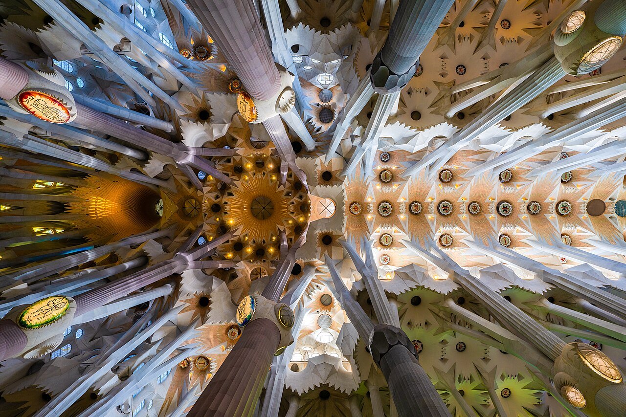 The vaults of the Sagrada Família seen from below, where the columns branch like trees.