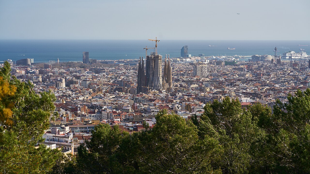 The Sagrada Família rising among the city's rooftops, with the sea behind.