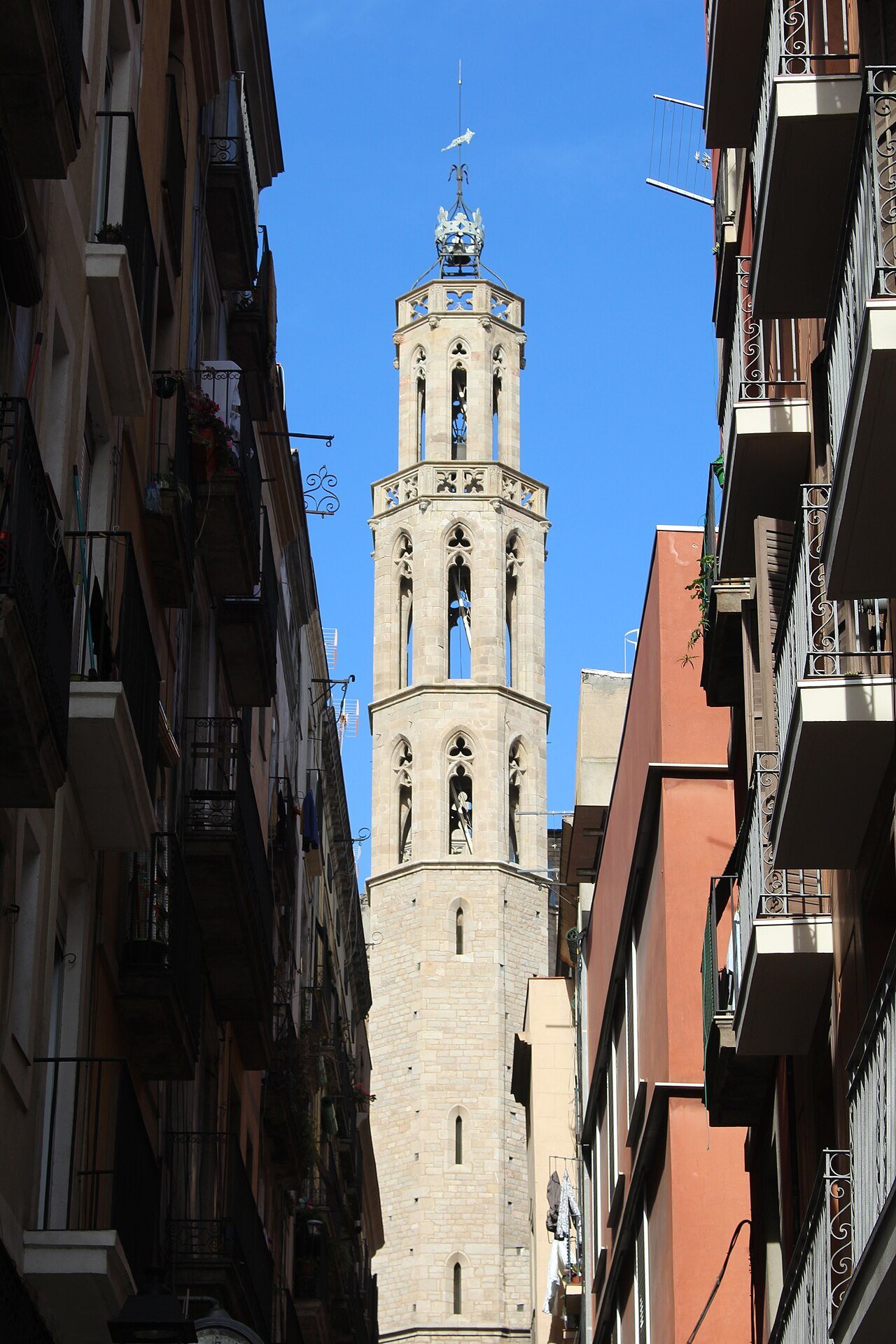 The bell tower of Santa Maria del Mar at the end of a narrow street.