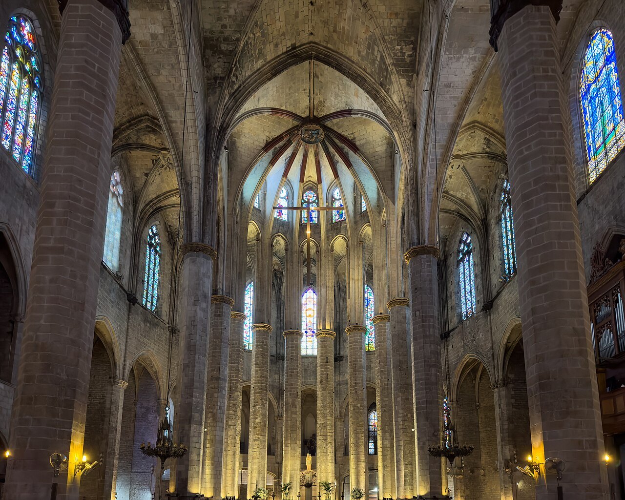The nave of Santa Maria del Mar looking toward the apse, with stained-glass windows on both sides.