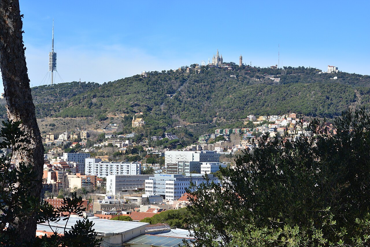 The wooded summit of Tibidabo above the city, with its church and a telecommunications tower on the skyline.
