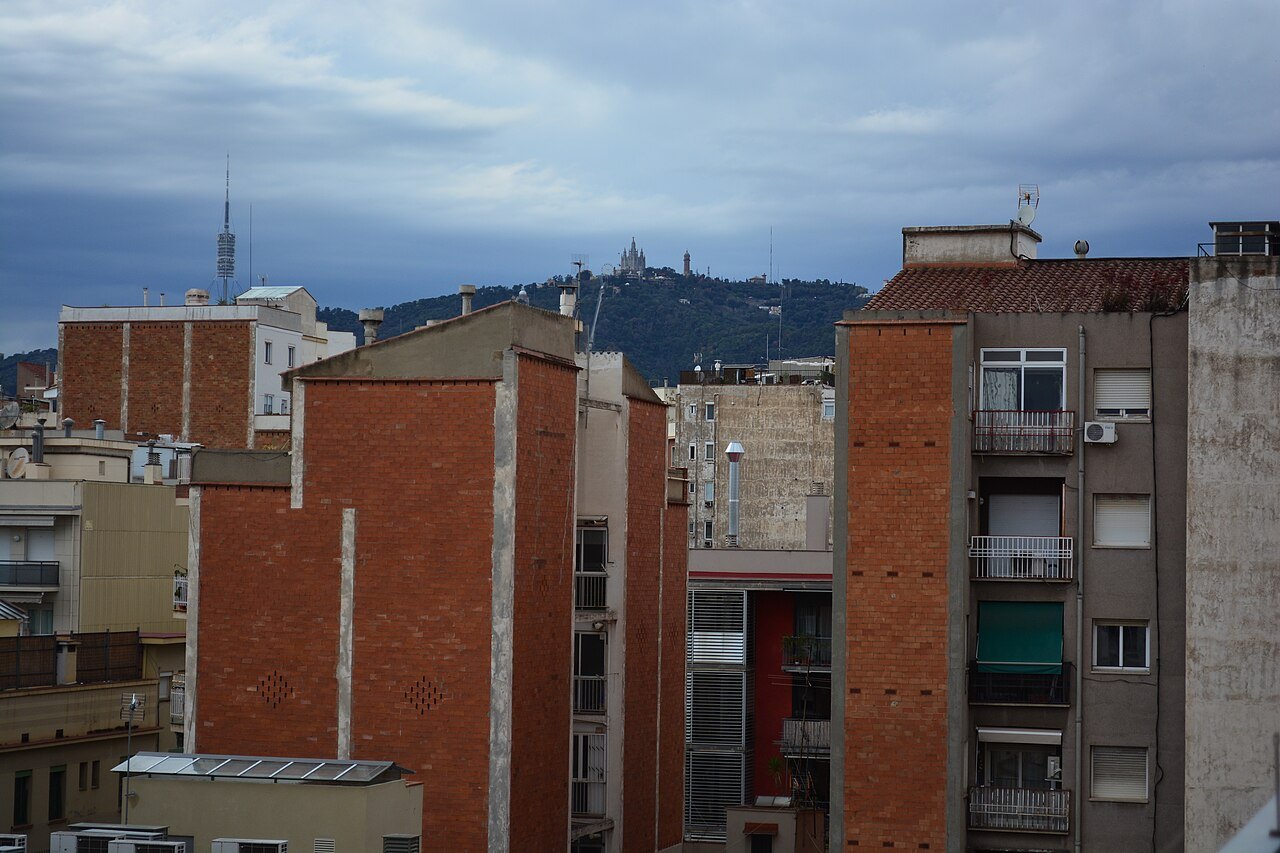 Brick apartment buildings with the hill of Tibidabo beyond.