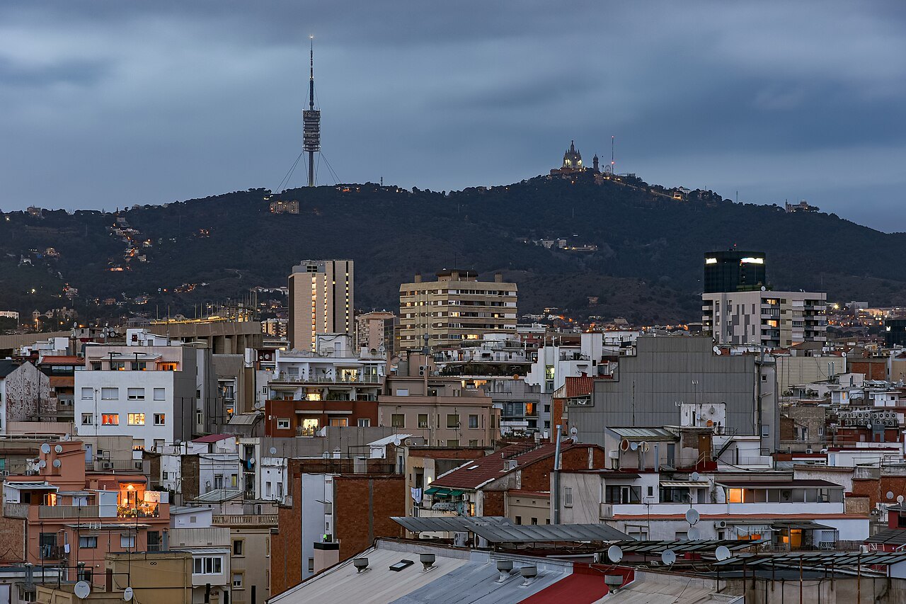 Rooftops of the city with a telecommunications tower and the hill of Tibidabo behind.